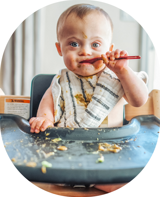A baby in a high chair eating food.